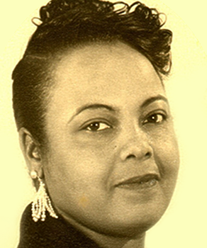 Portrait of a woman with a calm expression, wearing elegant earrings and a curled hairstyle.